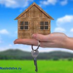 A man holds a wooden house and keys in his palm